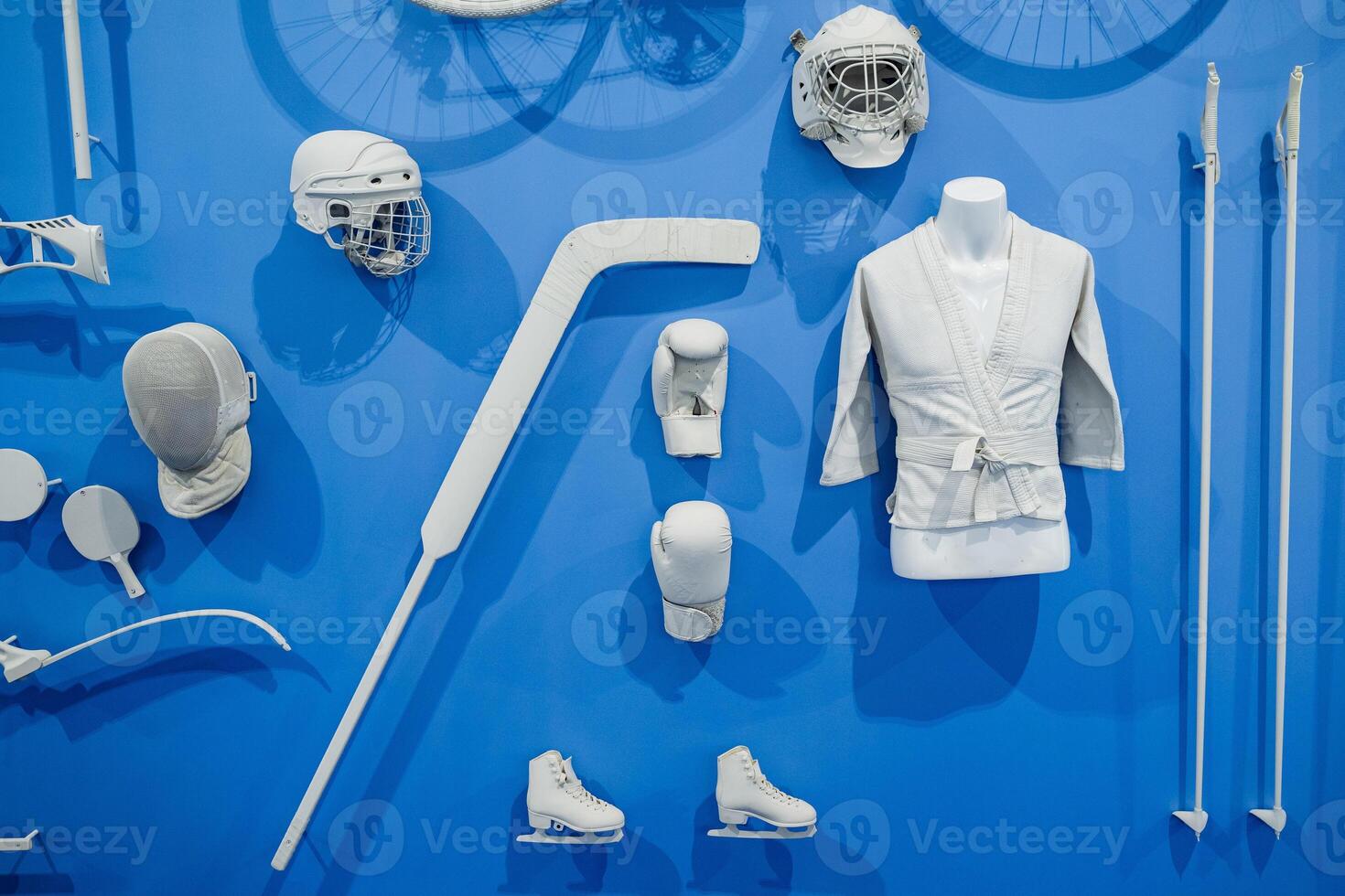 A vibrant blue wall, adorned with various sports equipment, showcases engaging shapes designed to inspire physical activity and encourage playful interaction among viewers photo