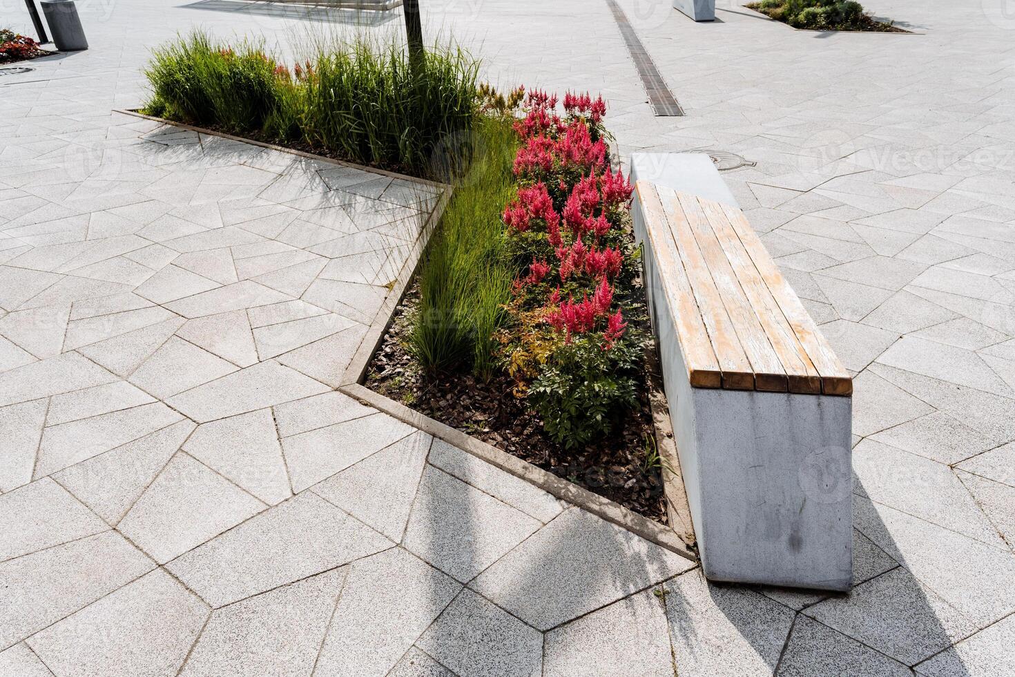 A sleek and modern urban park bench is surrounded by vibrant fresh floral landscaping, enhancing the contemporary aesthetic of the cityscape with its modern design photo