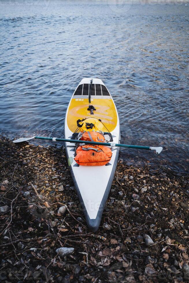 SUP board rafting on the river in high water, summer adventure on the lake, paddleboarding, paddle boat, extreme recreation. photo