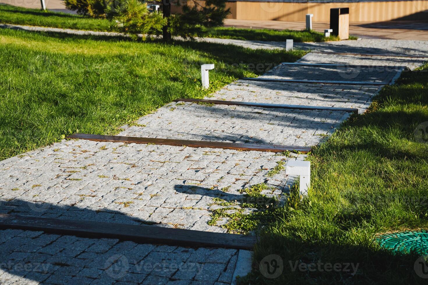 A beautiful brick walkway meanders through a lush, vibrant green field, creating a stunning contrast with the natural surroundings that enhances the overall landscape appeal photo