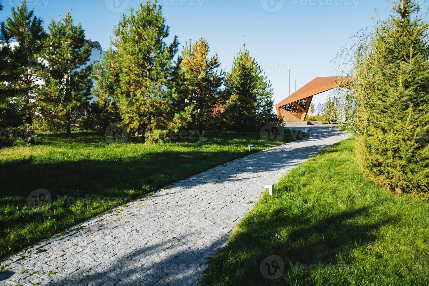 A scenic pathway that gracefully winds through lush greenery, featuring a modern architectural element that enhances its natural beauty photo