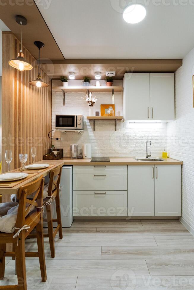 In a wellequipped kitchen, there is a lovely table surrounded by chairs, alongside a microwave for heating food, creating a functional and inviting space for meal preparation and gathering photo