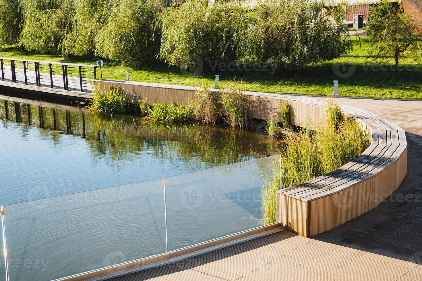 Experience the tranquil beauty of Serene Waterfront Park, featuring curved benches nestled among lush greenery, inviting exploration and relaxation photo