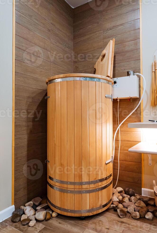 In the corner of a cozy bathroom, there is a wooden barrel casually resting next to a bathtub, adding a rustic touch to the overall decor of the space, creating a unique ambiance photo