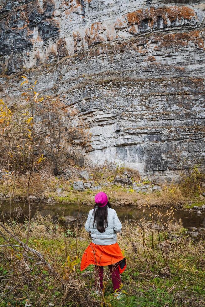 An explorer dressed in traditional attire stands amidst a majestic rocky landscape, embodying adventure and the spirit of exploration photo