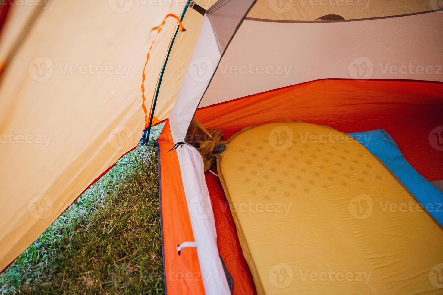 To enhance your camping experience, create a cozy atmosphere in your tent with an air mattress. It provides comfort and safety for a relaxing wilderness adventure photo