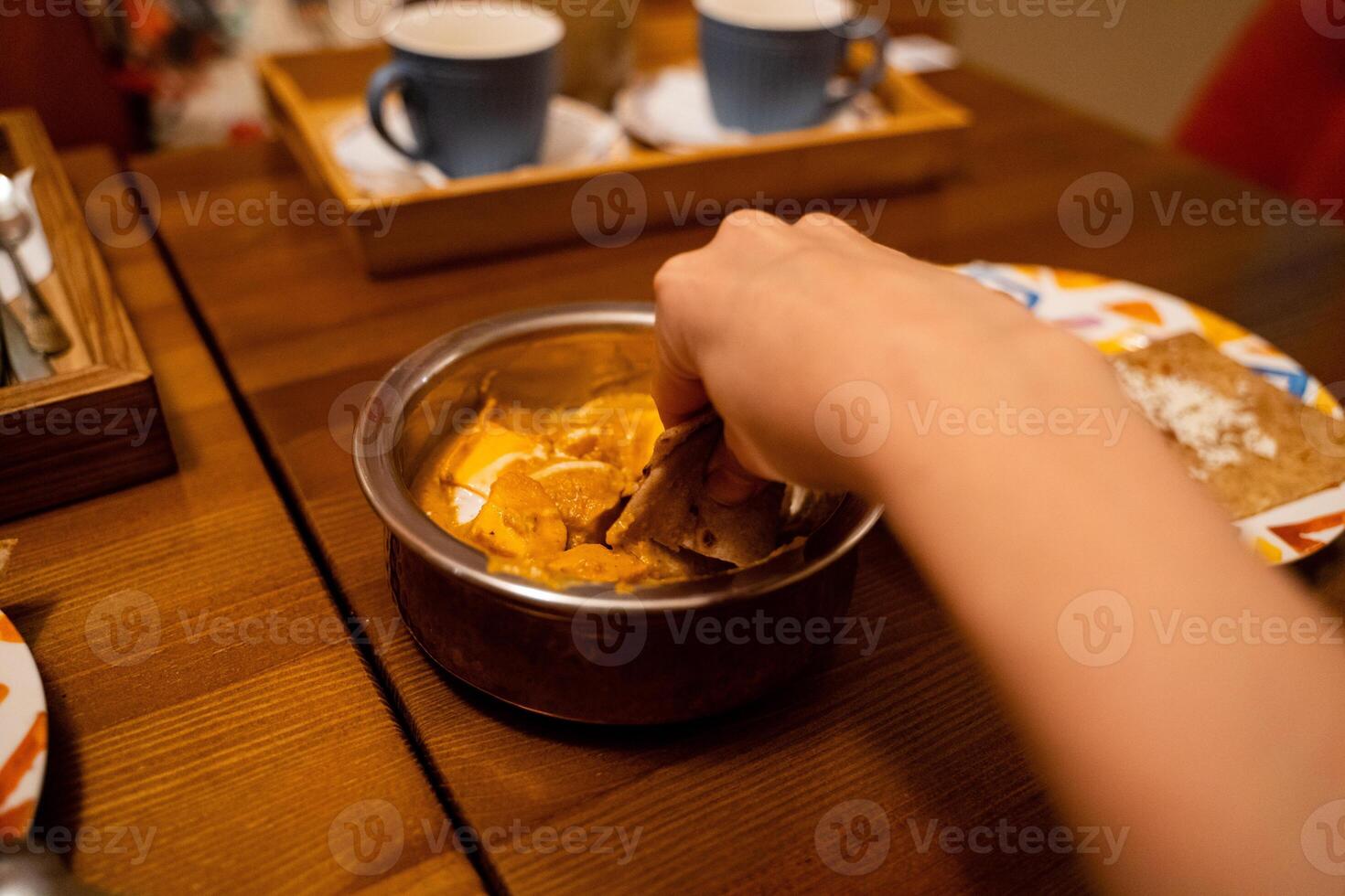 An individual enjoys a delightful array of food artfully arranged in a beautifully designed bowl on a welldressed table, creating a satisfying and joyful dining experience photo