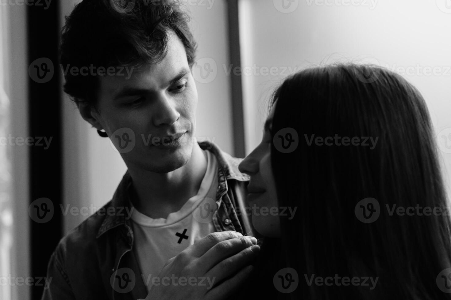 Couple sharing a tender moment in a cozy indoor setting during evening hours photo