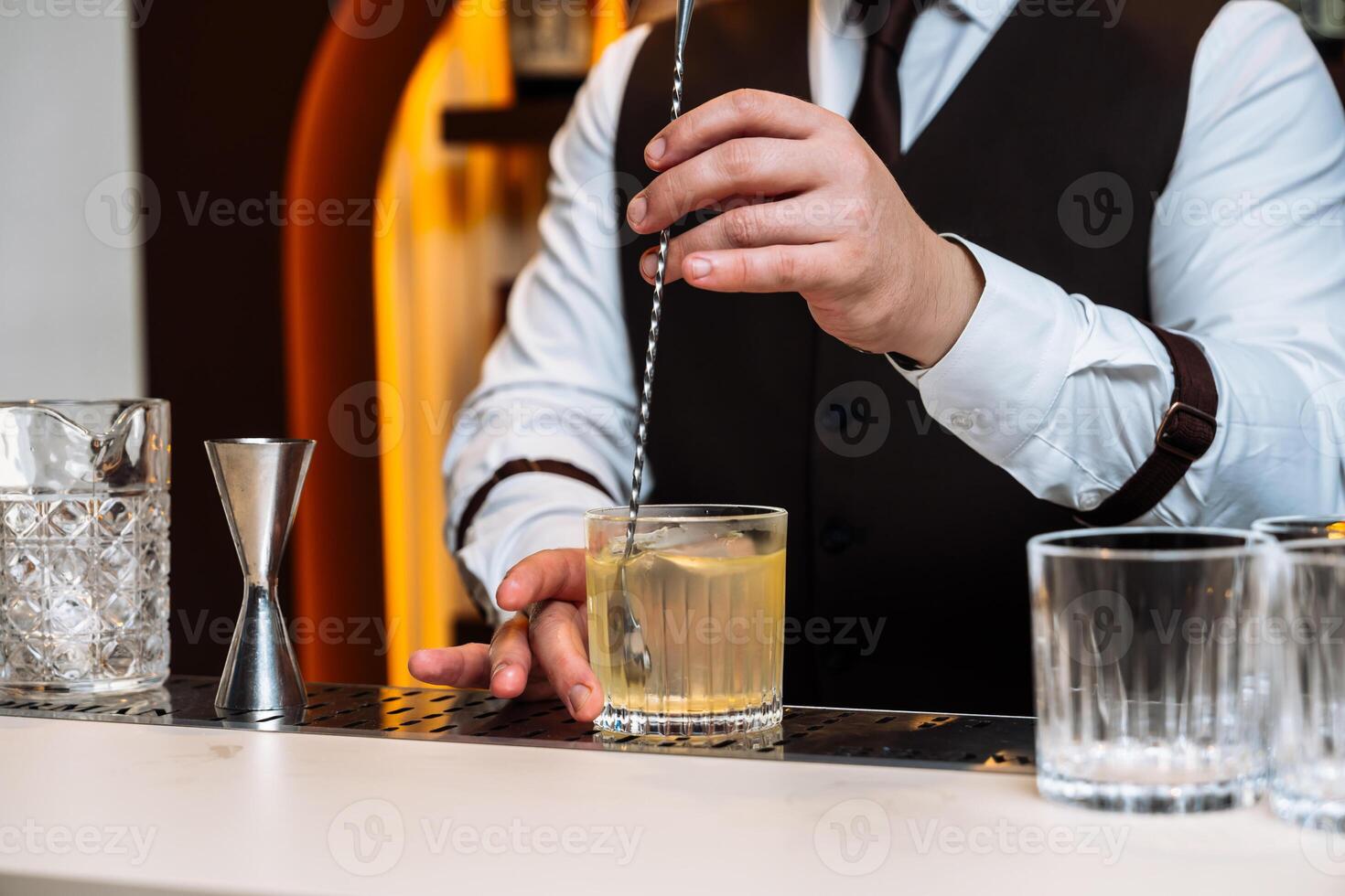 Bartender preparing a cocktail at a stylish bar during an evening event photo