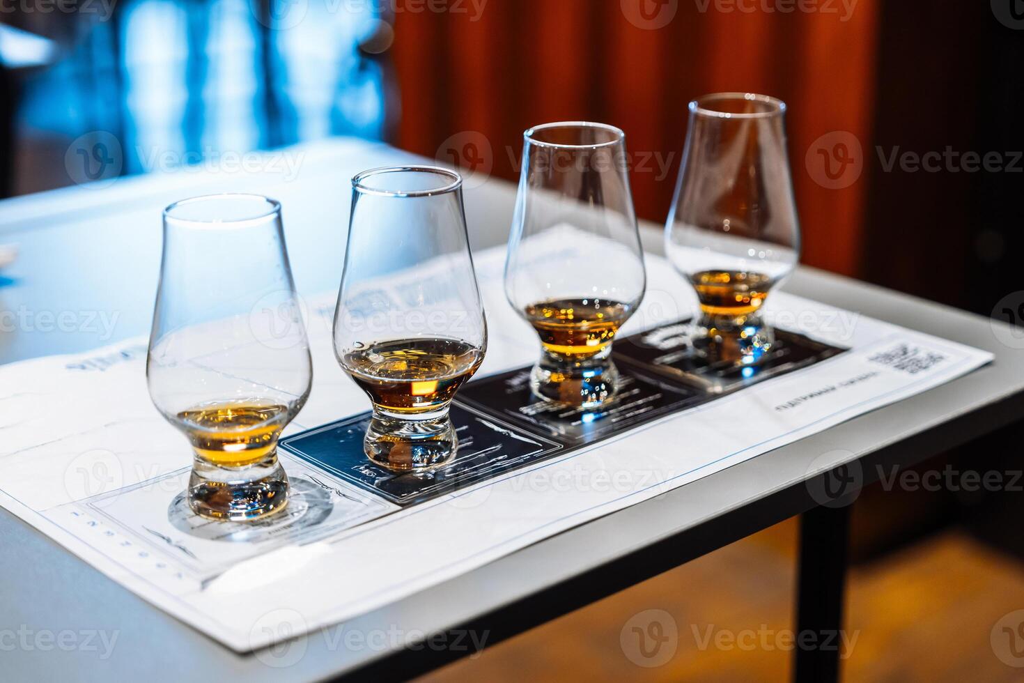 Enjoying whiskey tasting with four glasses and tasting notes on a table photo