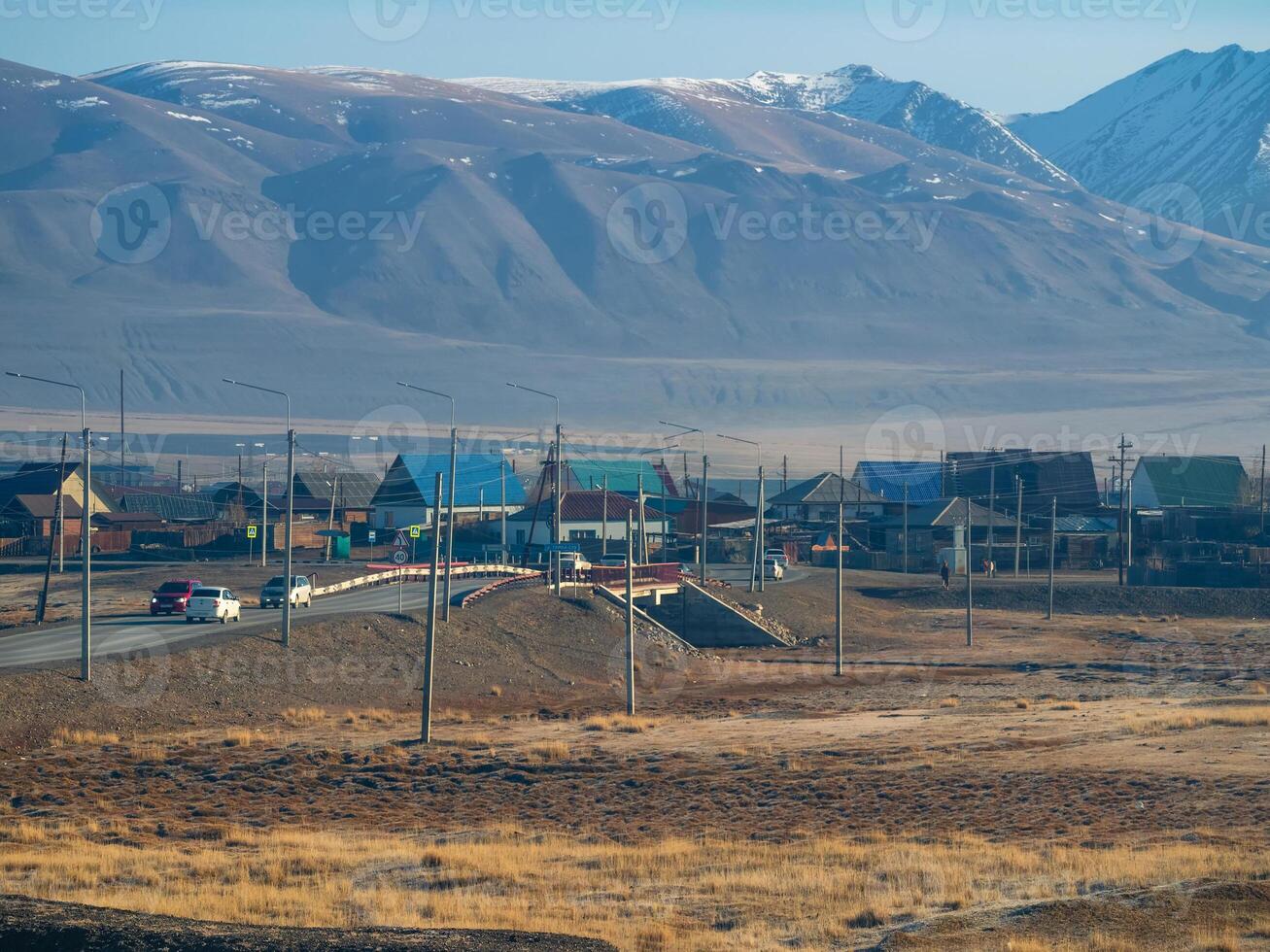 View of the village bridge in Kosh-Agach. Rural traffic of cars. Landscape with a village in a mountain valley. Russia, Altai Republic. photo