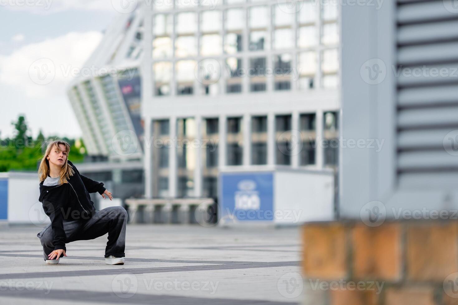 Dance performance on urban pavement with modern architecture in background photo