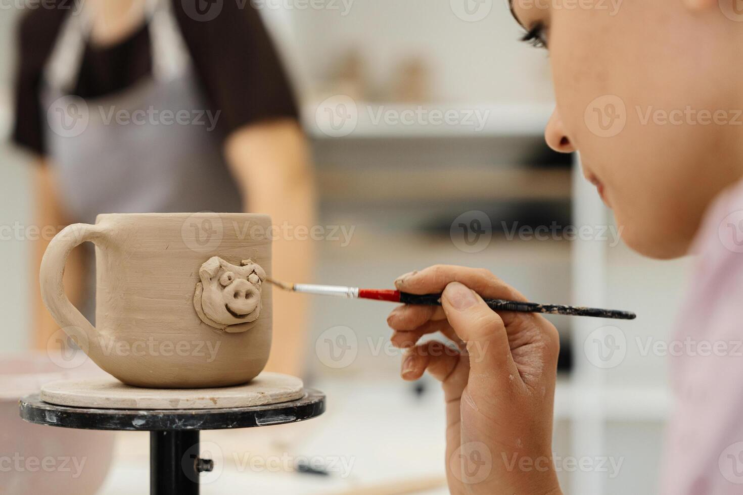 Crafting and painting a unique pig mug in a pottery workshop environment photo