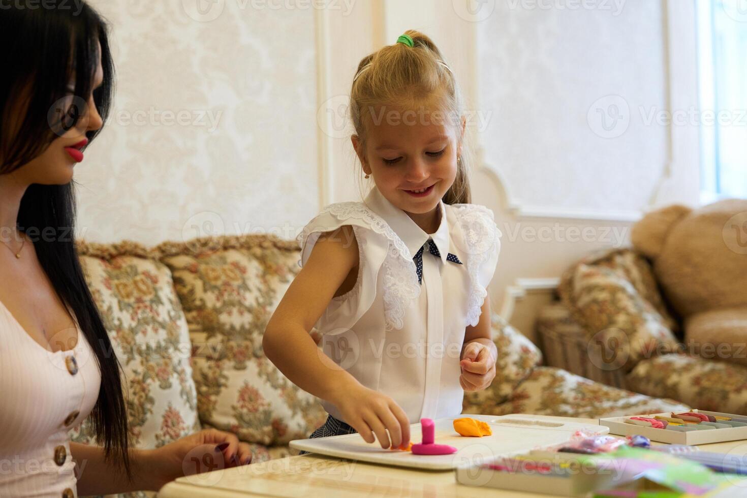 Young girl enjoys creating with colorful modeling clay in cozy living room photo