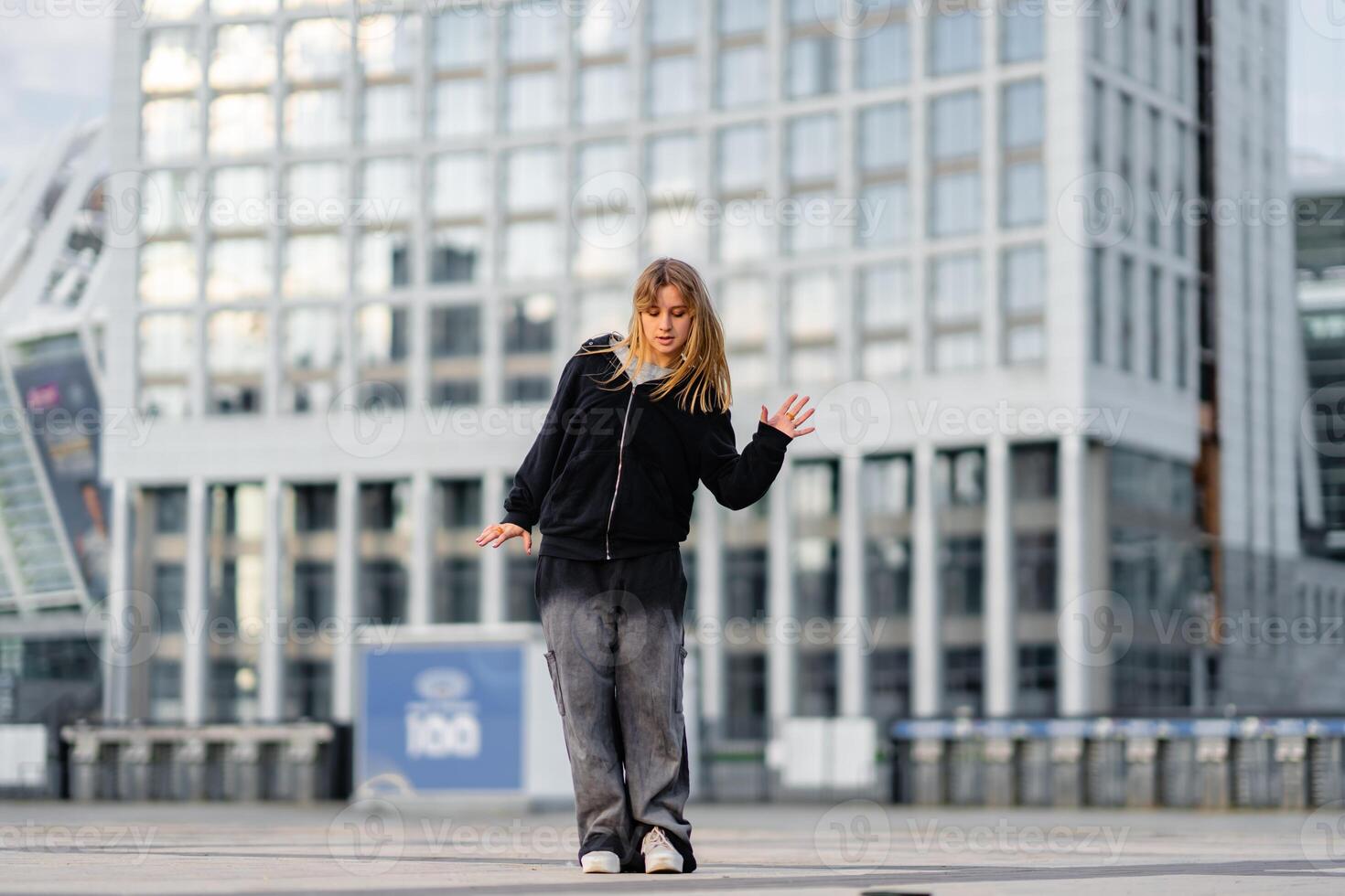 Dancer performs contemporary routine in urban setting during late afternoon photo