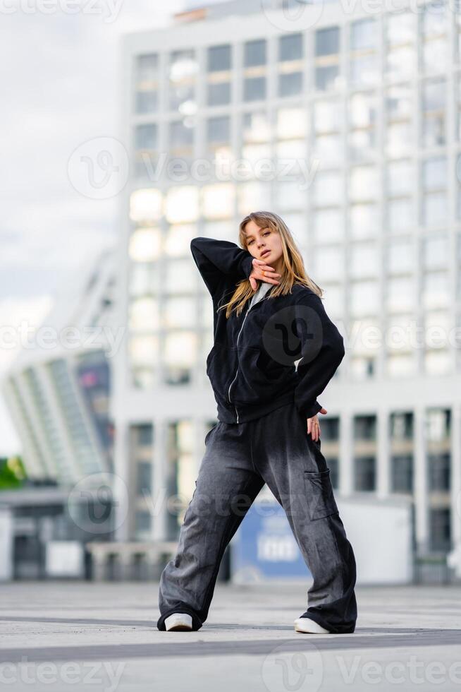 Dancer performs stylish routine in urban setting during afternoon photo