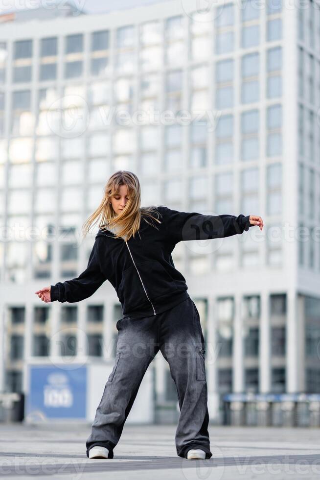 Young dancer performing a contemporary routine in an urban setting photo