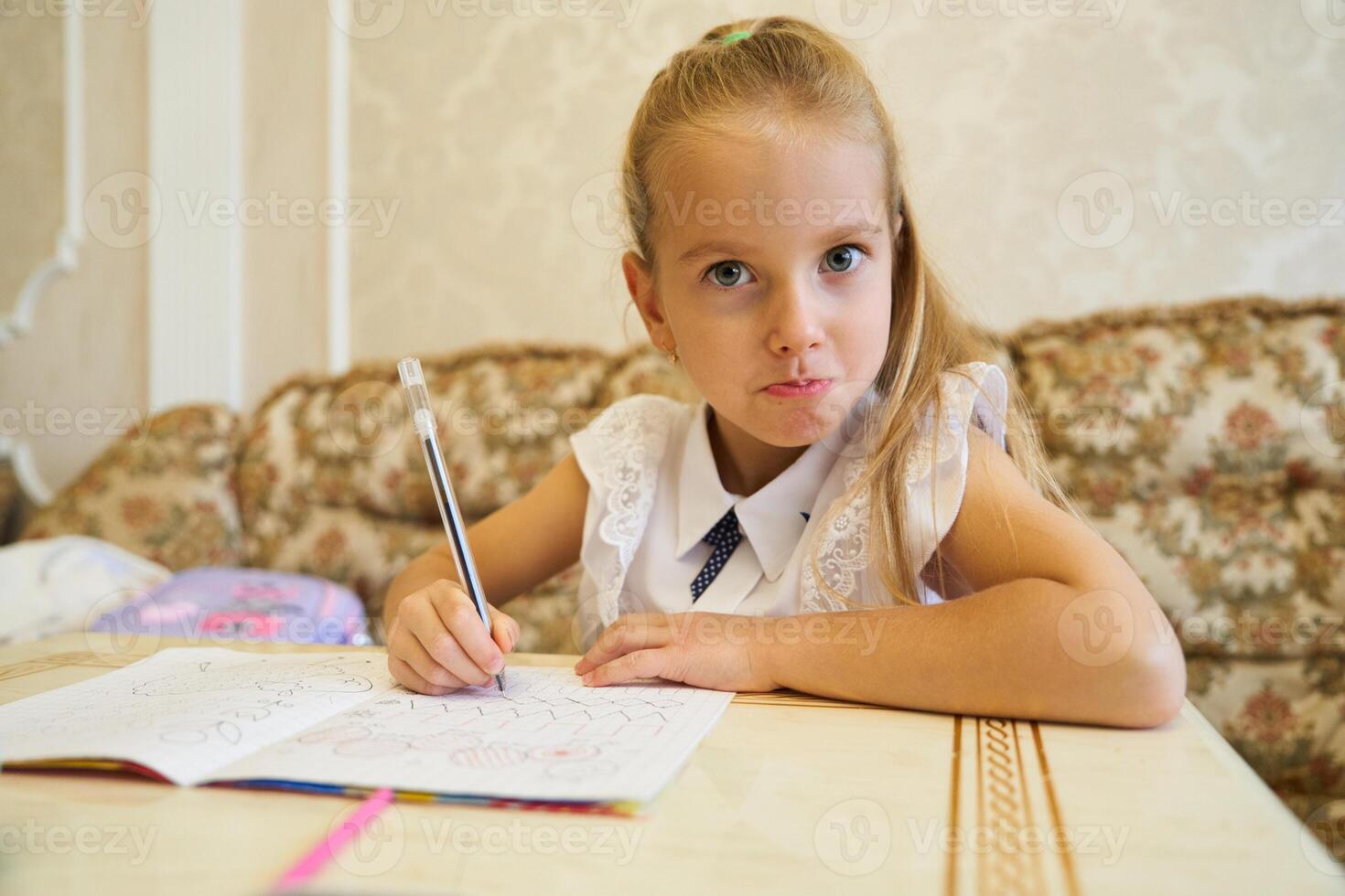 Young girl engaged in creative coloring at home on a sunny afternoon photo