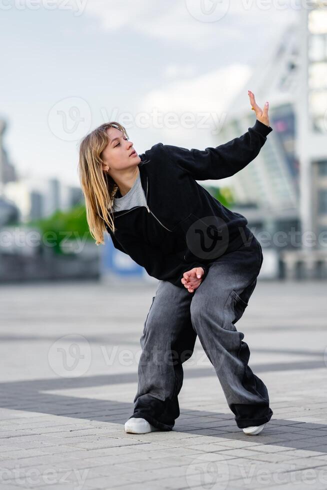 Dancer performing an expressive dance move in an urban setting photo