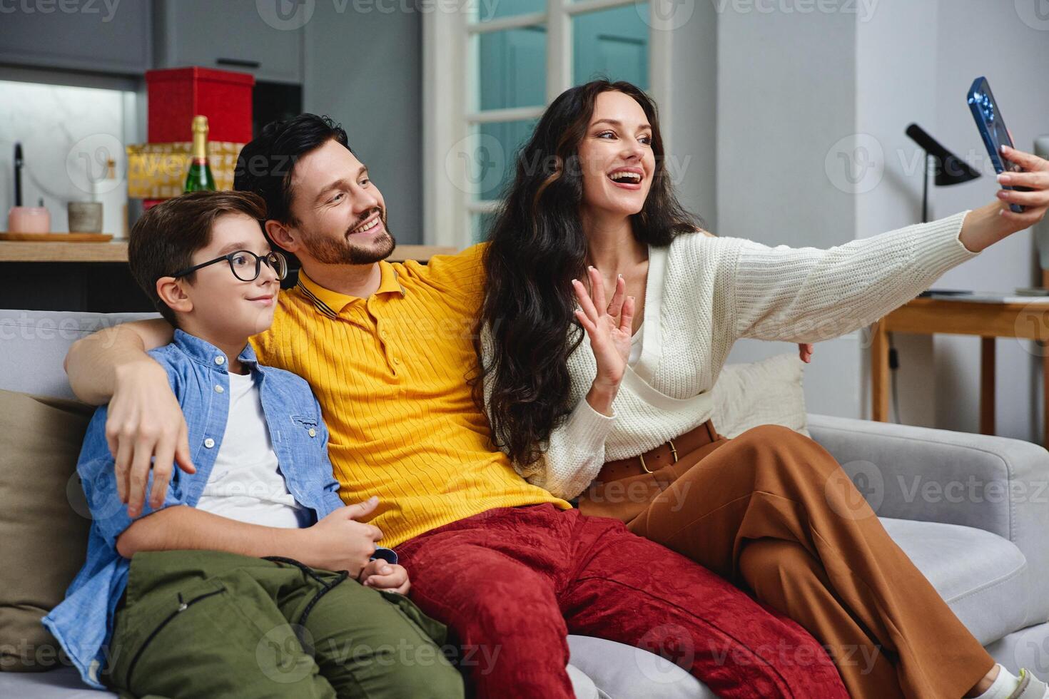 Family enjoying a cheerful moment while taking a selfie at home photo