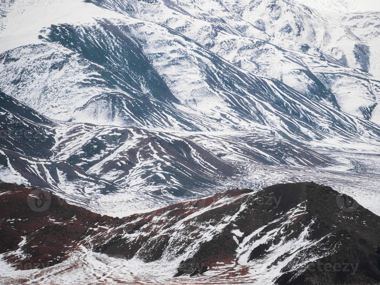 Texture of snow-capped mountains. Minimalist nature background of snowy mountainside. Misty mountain minimalism of snowbound mountain in low clouds. photo