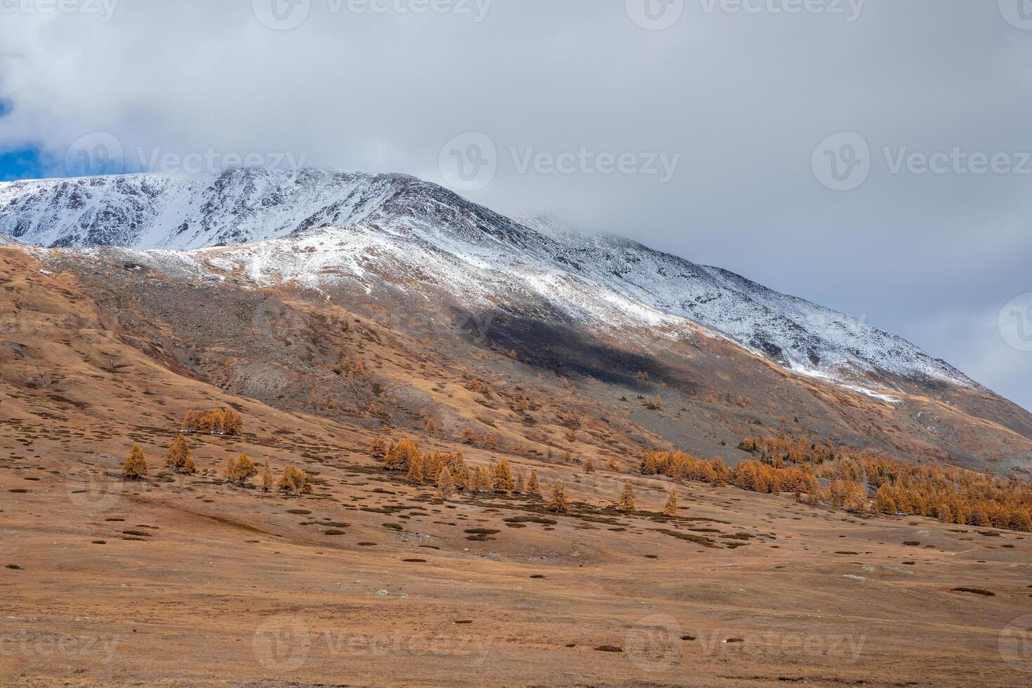 Snow clouds float over the autumn wooded mountain valley photo