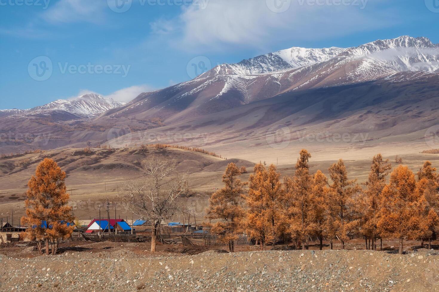 village in autumn, against the background of a snow-covered mountain photo