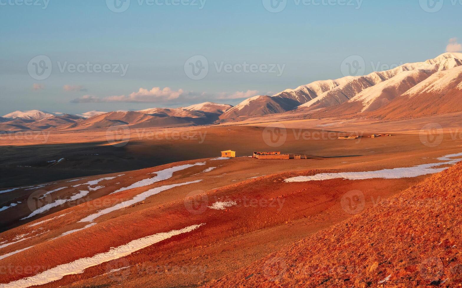 Wooden house on red dry grass, a mountain landscape photo