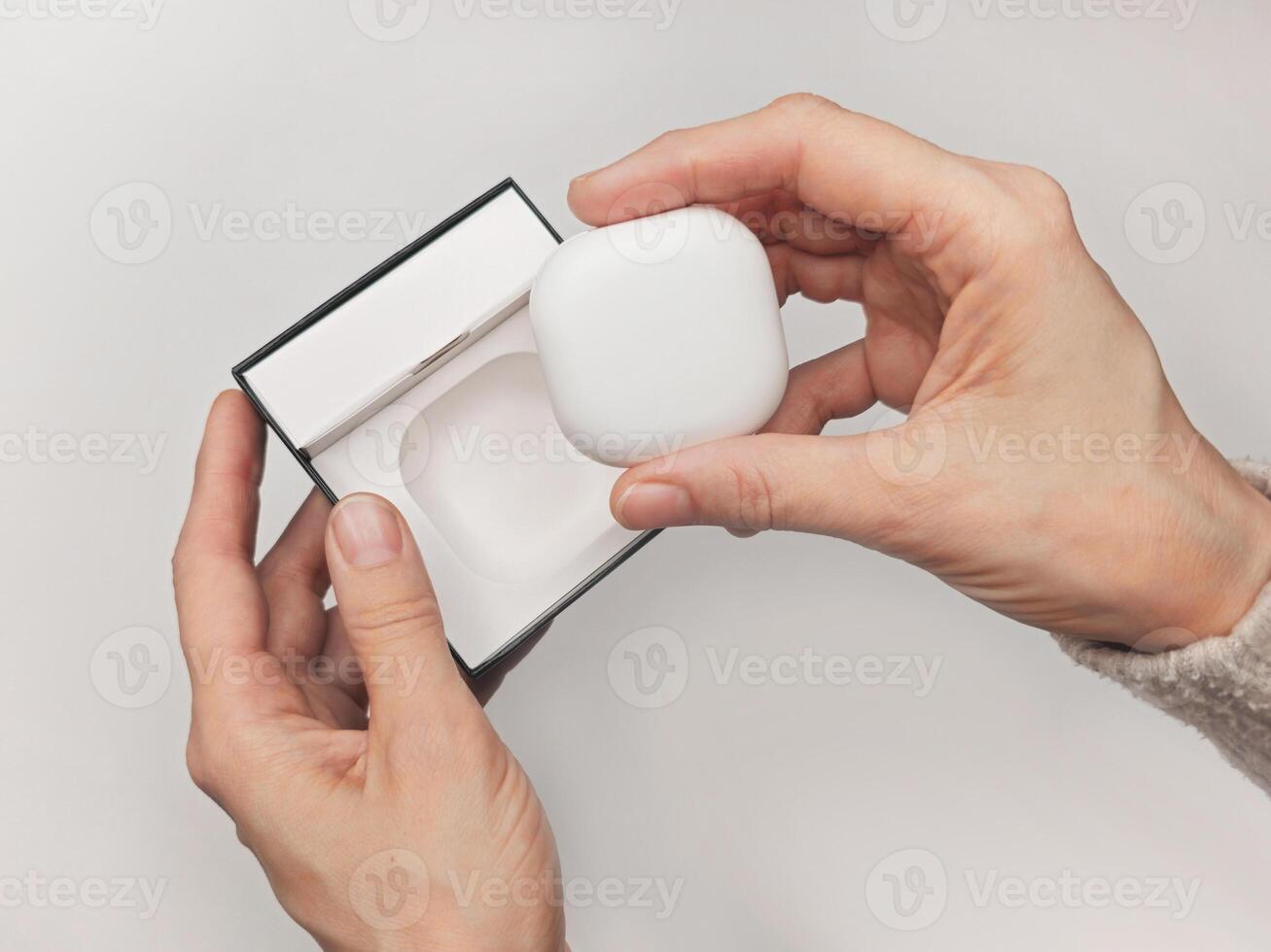 woman hand actively unboxing the latest wireless earbuds contain photo