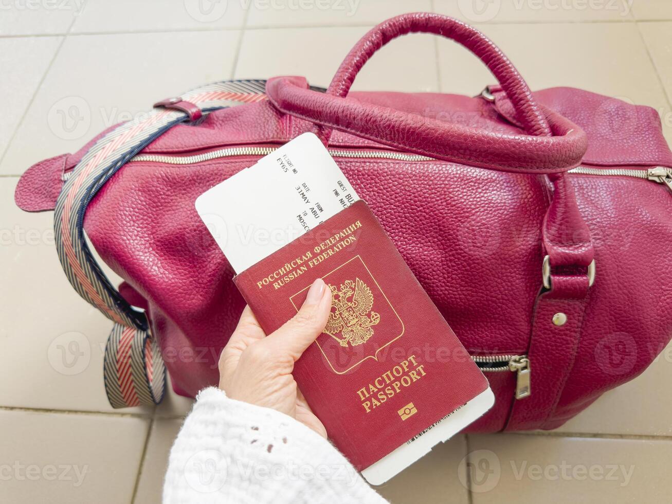 Russian red passport and boarding pass in a woman hand photo