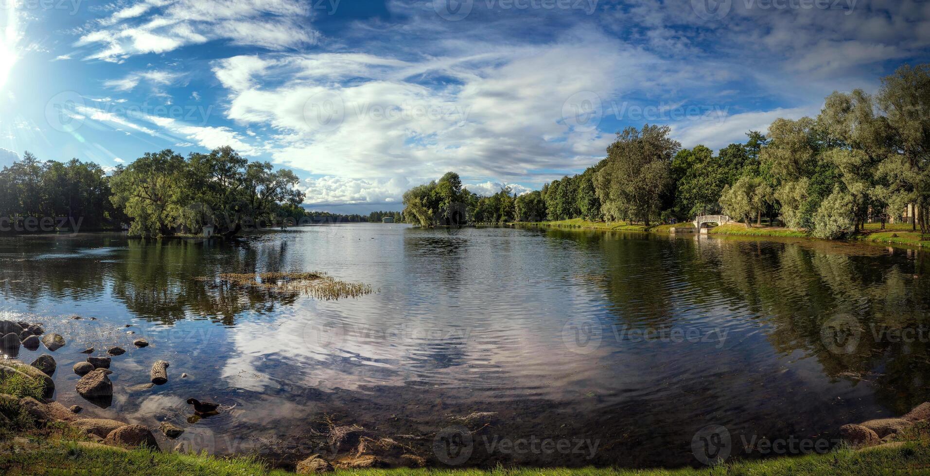 Beautiful panoramic view with sun over the lake and reflections in the water. photo