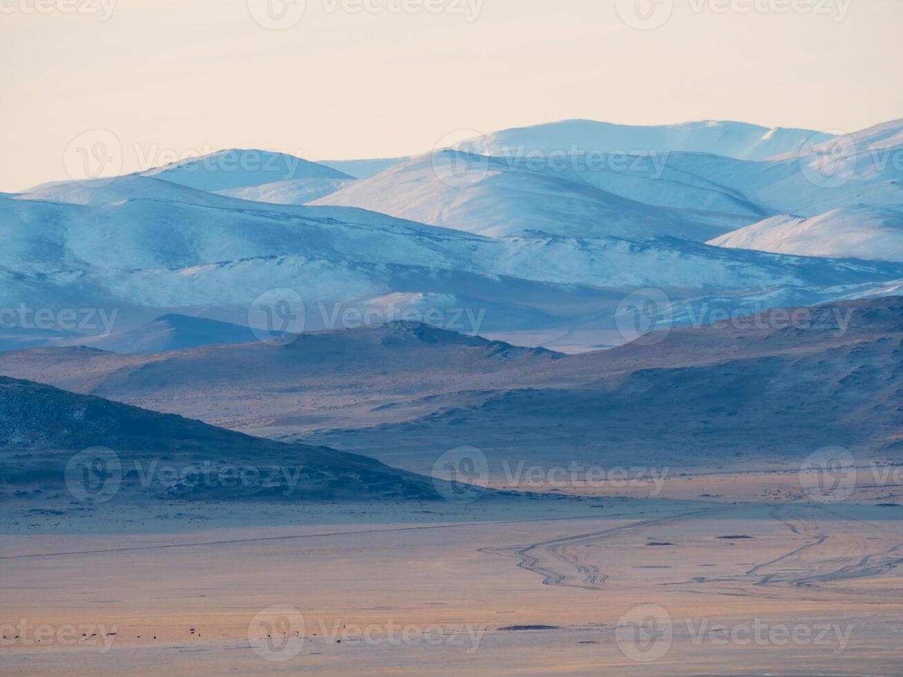 Layers of mountains on distance, soft pink sunset in mountain landscape. Layers of mountains background. Silhouette of the evening mountains at sunset. photo