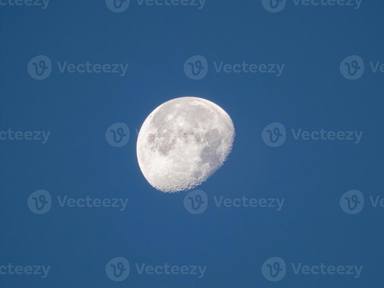 Three quarters of the moon in the evening dark blue sky. photo