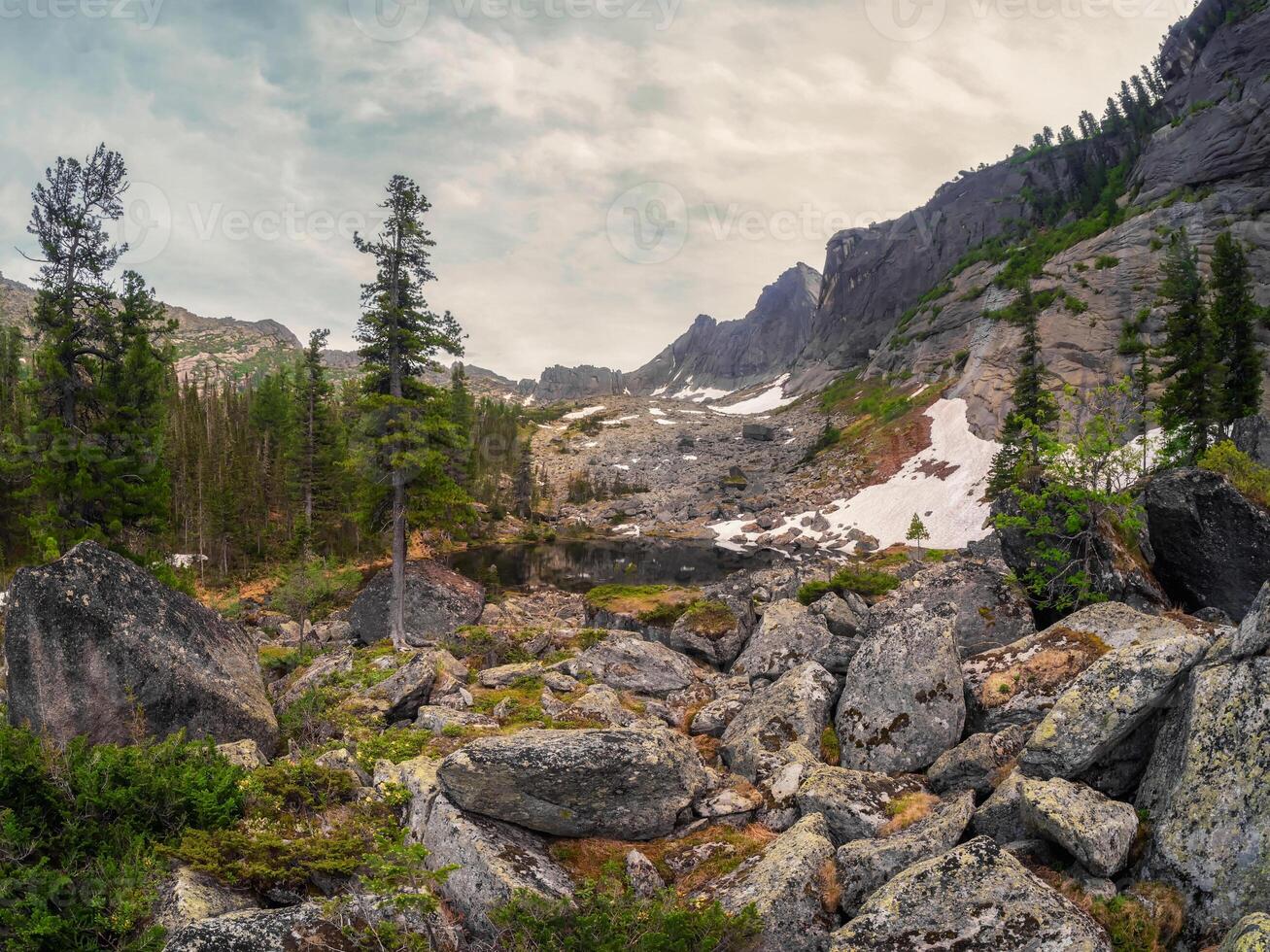 Mountain black lake in the block stream valley. photo