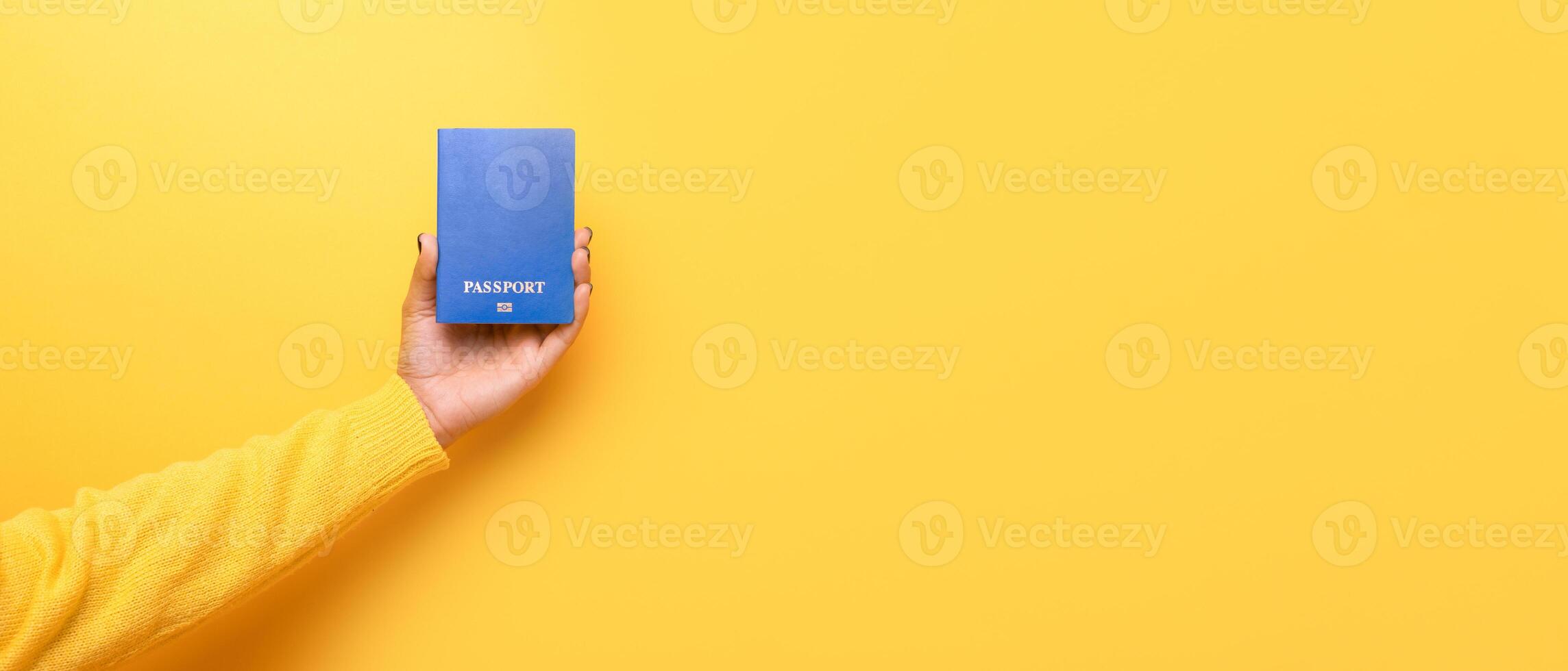 passport in hand over yellow background photo