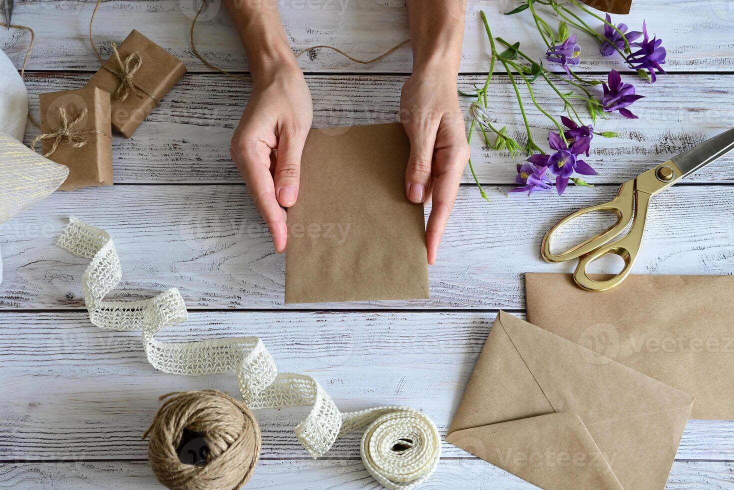 This image features a hand-tied bouquet of white flowers being wrapped with a textured white ribbon. photo