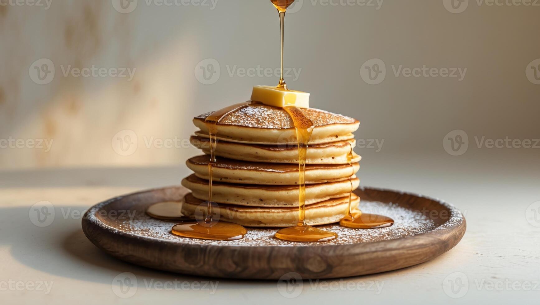 Delicious pancakes served with honey and powdered sugar on wooden plate. photo