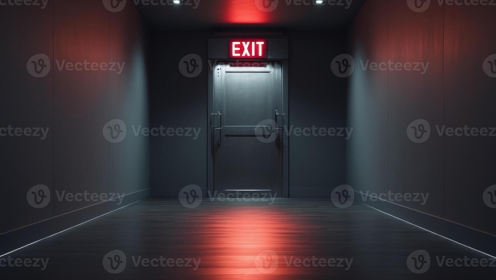 Dimly lit corridor with red exit sign above closed doorway. photo