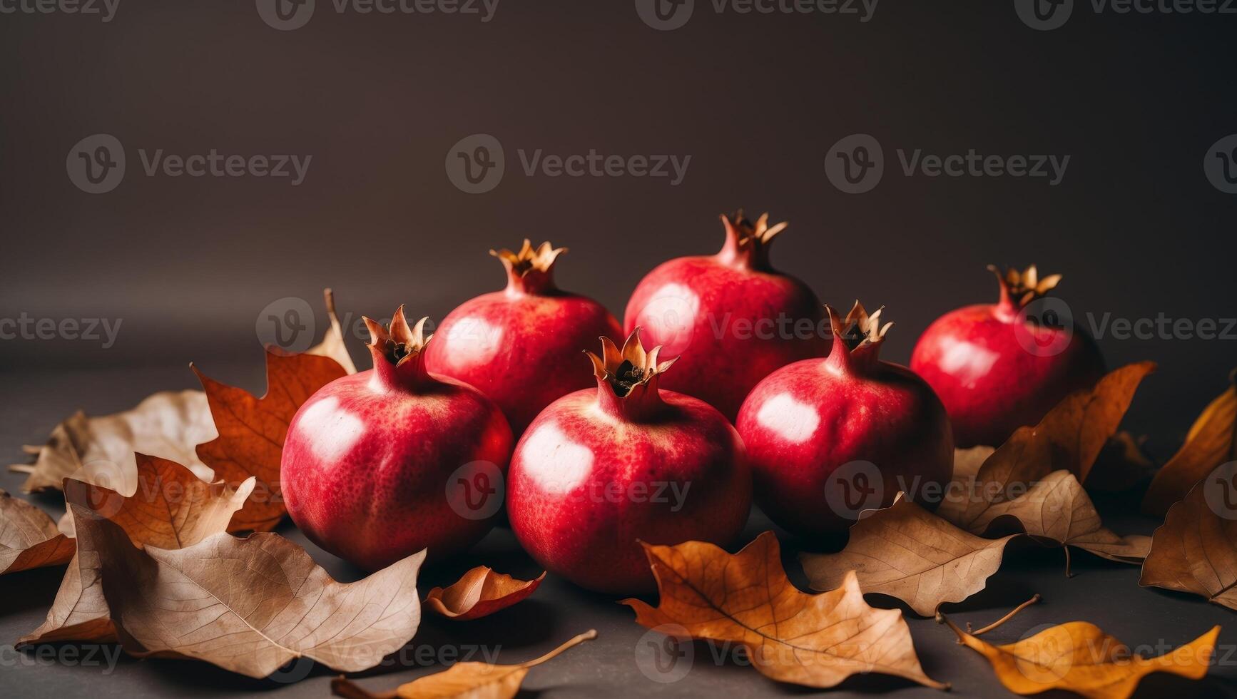 Red pomegranates and dry leaves on dark background reflecting autumn harvest vibe photo