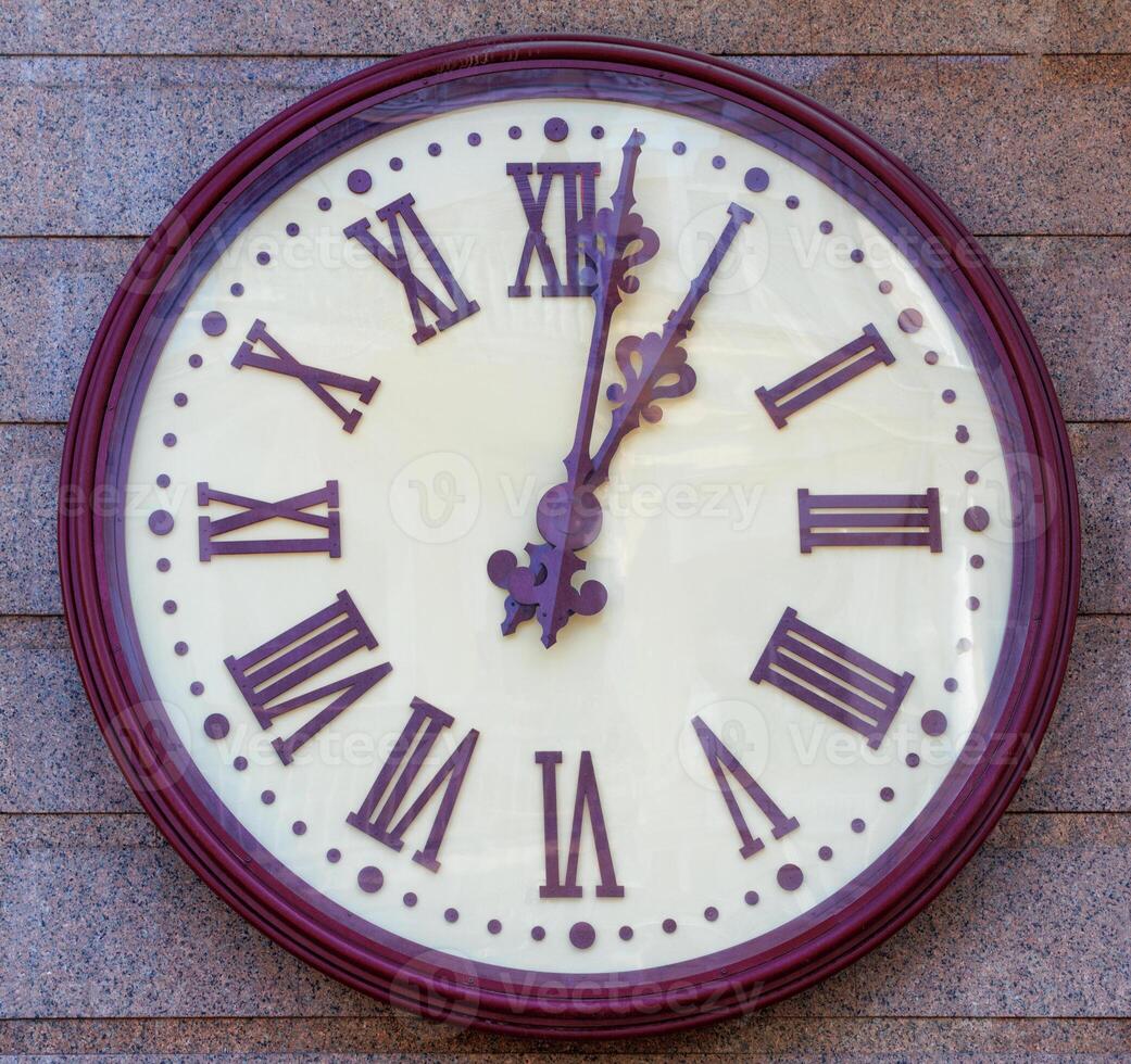 Large round wall clock on the granite facade of the house. photo