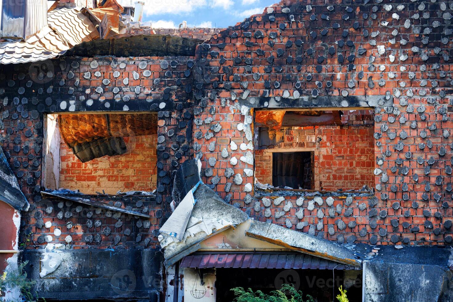 Window openings of a destroyed and burnt-out rural Ukrainian house after Russian aggression. photo