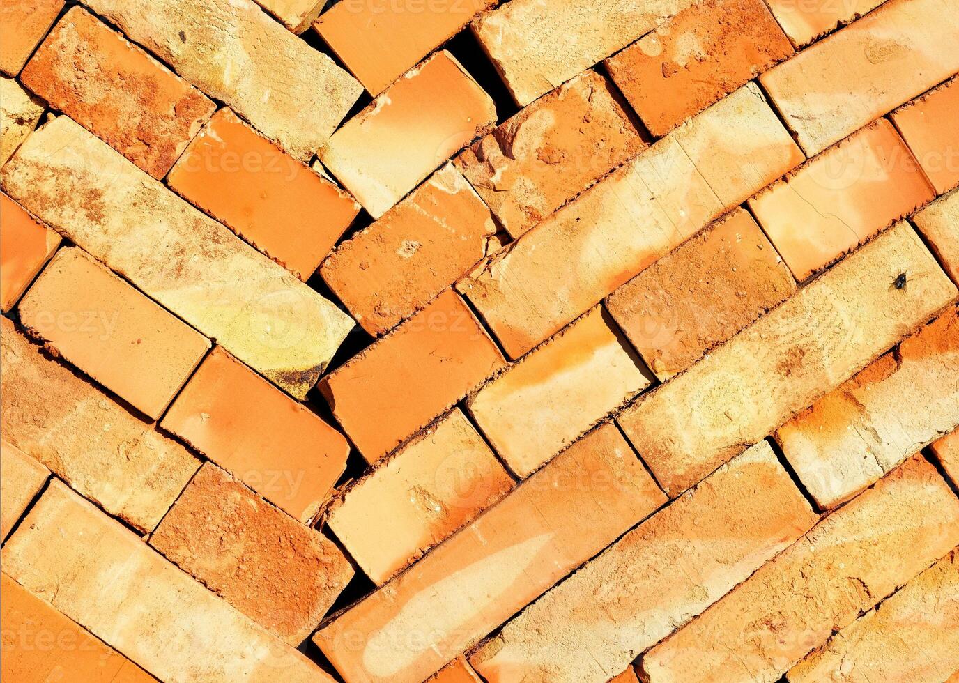 The texture of an orange stacked brick illuminated by the sun's rays. photo