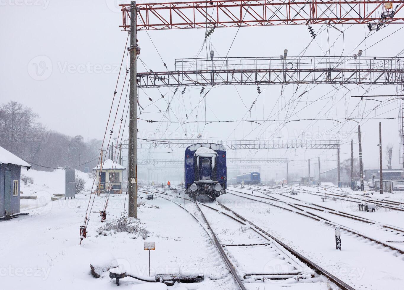 Railway train carriage resting on the tracks during snowfall on a winter day. photo