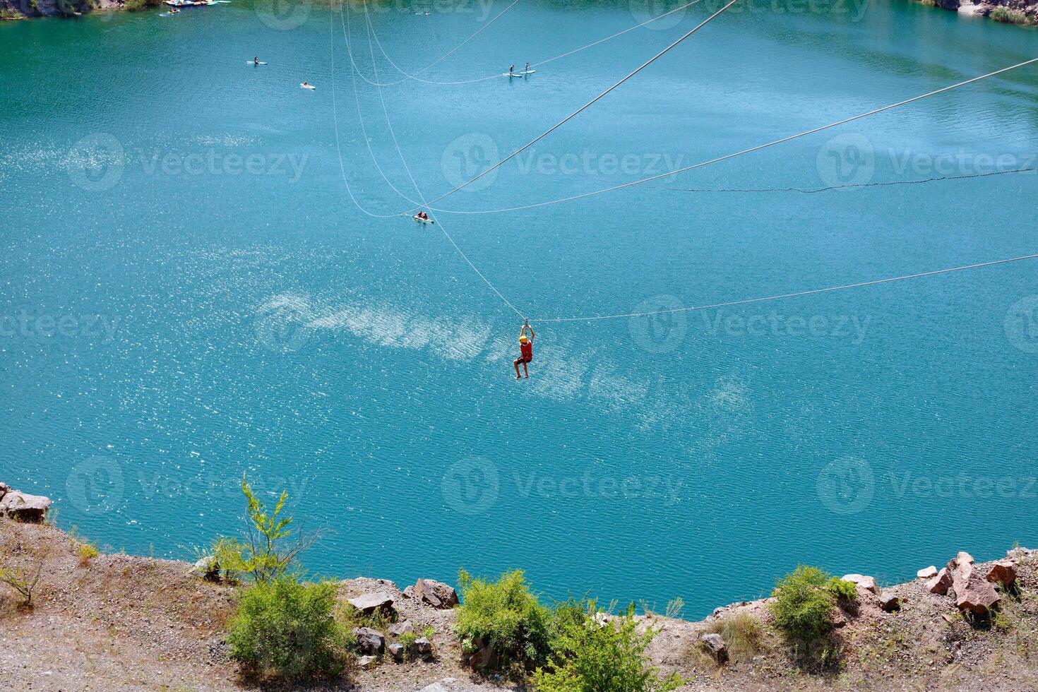 Tourists cross a large lake on a cable car on a summer day. photo
