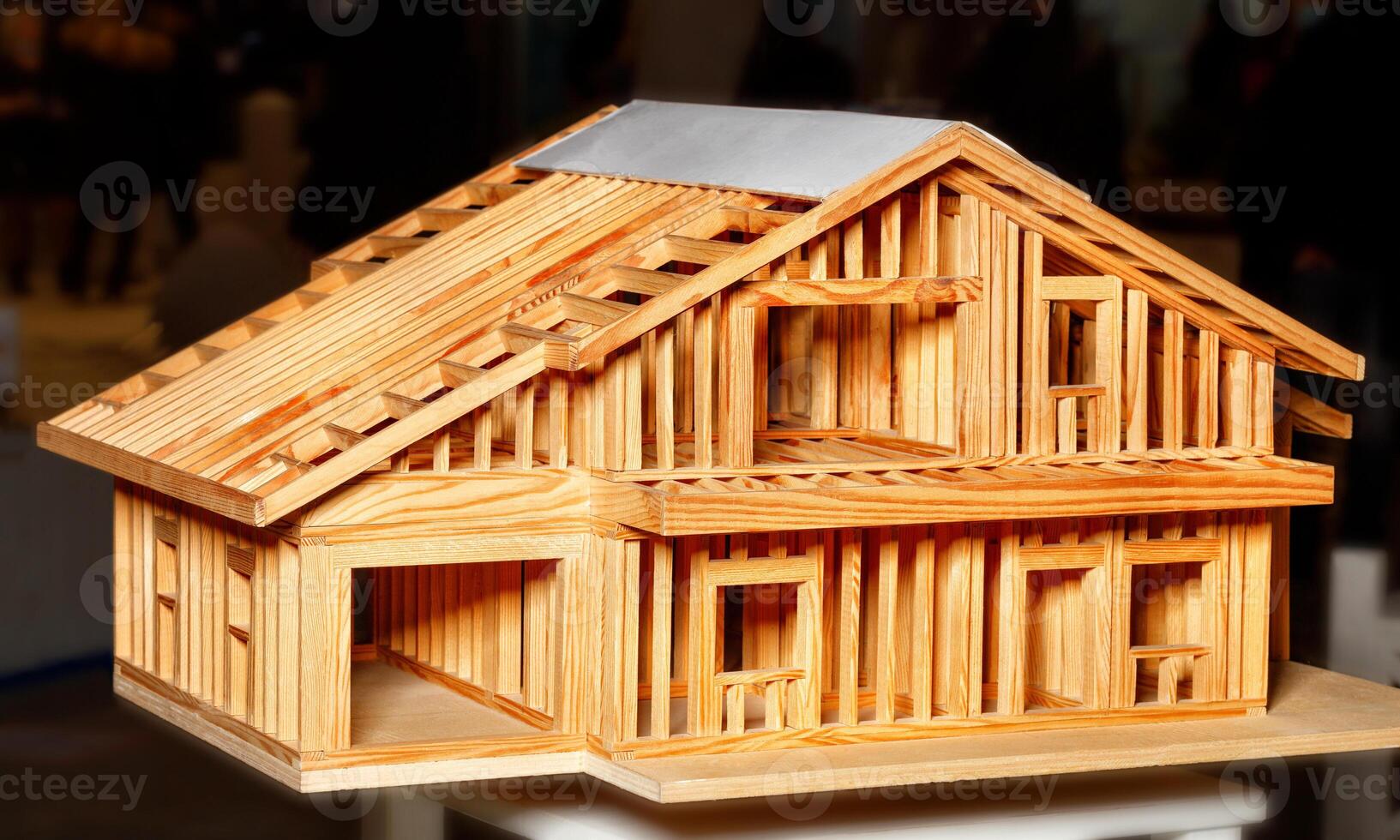 Model of a wooden frame of a residential building. Image on a dark background. photo