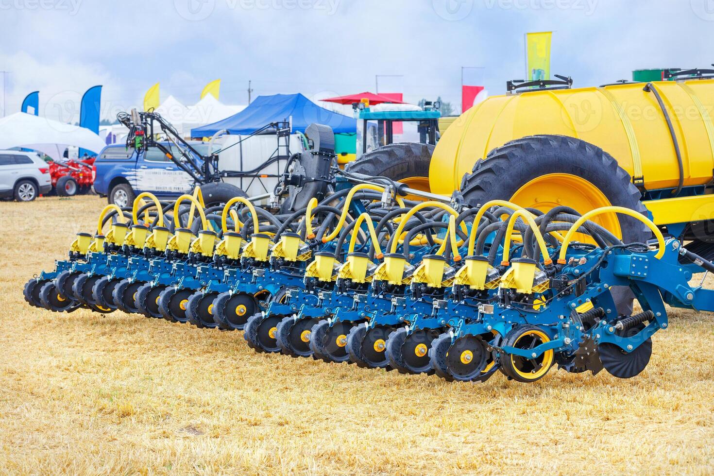 A multi-row seeder with a pneumatic mechanism on the background of an agricultural field on a sunny day. photo