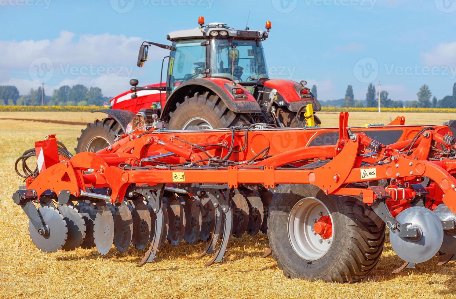 Powerful multi-row disc harrow on the background of agricultural field. photo