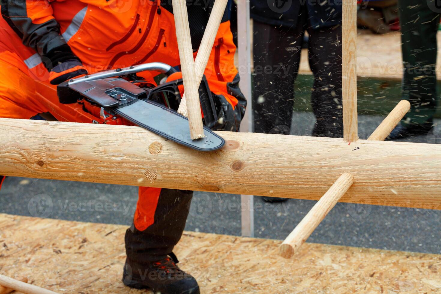 A lumberjack with a chainsaw at a competition to demonstrate professional use of the tool. photo