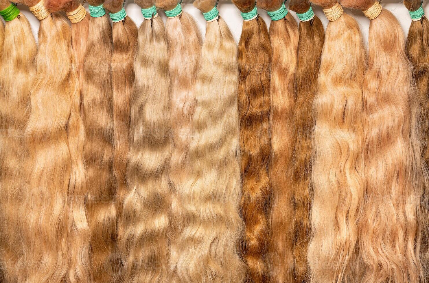 Beautiful wavy bundles of human hair in straw shades of color for extensions and making hairstyles. photo