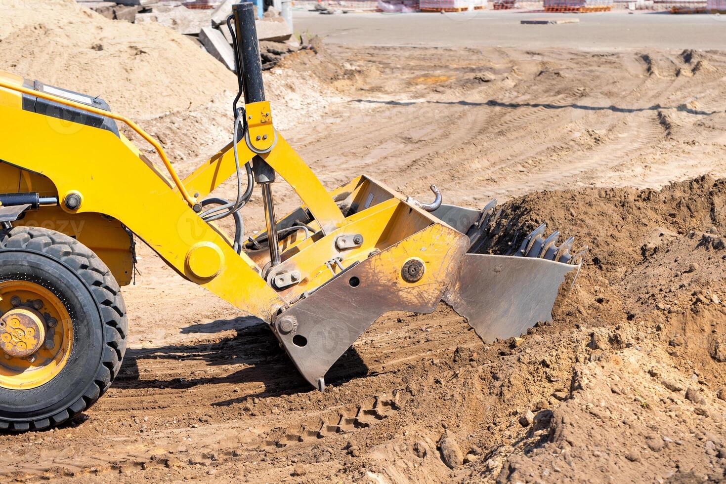The hydraulic mechanism of the metal bucket of a wheeled bulldozer at the work site. photo